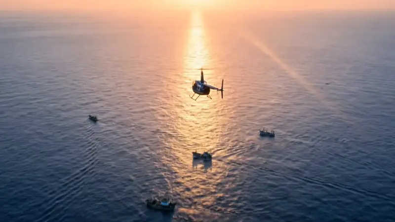 Vista amplia del R44 sobre el mar con barcos pesqueros dispersos